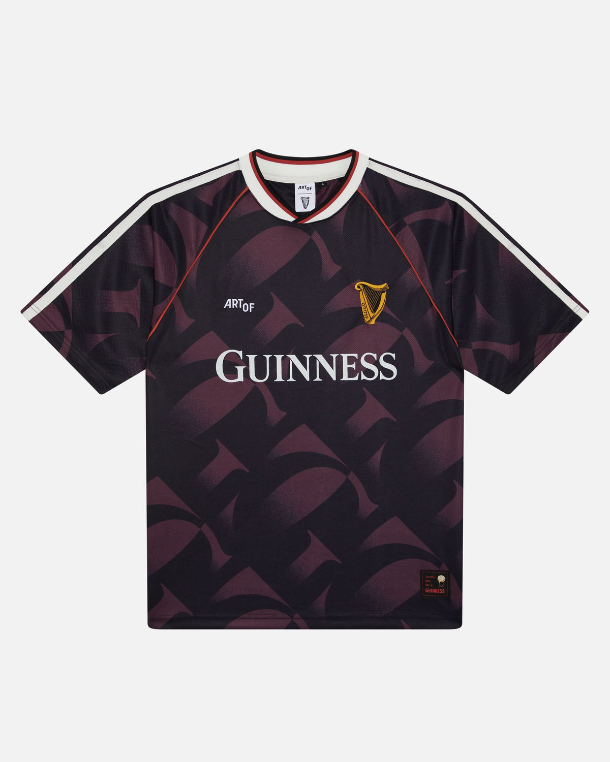 A short-sleeve Guinness football jersey with a dark purple and black geometric pattern, featuring the white 'GUINNESS' sponsor logo on the chest, a gold harp crest, and white shoulder stripes.